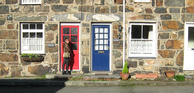 the gf opening a red door into a stone built cottage at beddgelert